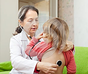 Pediatrician examining child with stethoscope