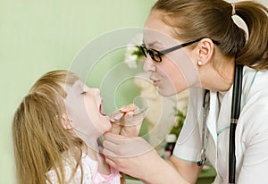 Pediatrician examining girl's throat