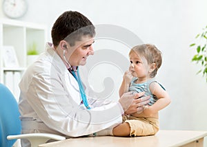 Pediatrician examining heartbeat of baby with