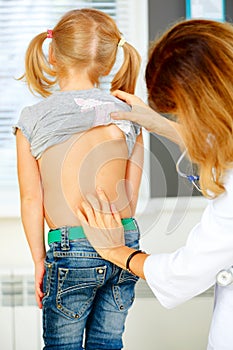 Pediatrician examining little girl