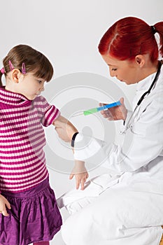 The pediatrician inoculating a small girl