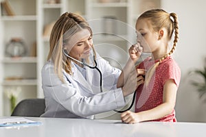 Pediatrician Lady With Stethoscope Listening Lungs Of Coughing Little Girl During Checkup