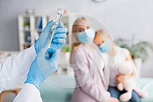 Pediatrician in latex gloves picking up photo