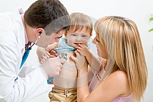 Pediatrician male doctor examining child. Mother