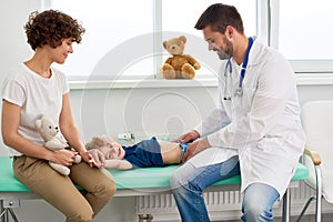 Pediatrician Palpating Stomach of Little Child