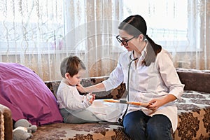 Pediatrician with a small patient at home. inspection of the baby