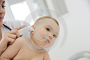 Pediatrician taking baby's temperature in ear