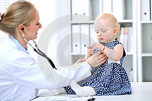 Pediatrician is taking care of baby in hospital. Little girl is being examine by doctor with stethoscope. Health care