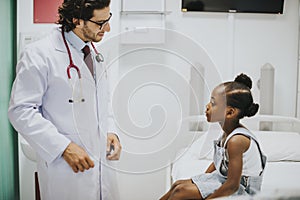 Pediatrician talking to his little patient photo