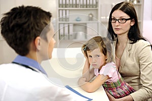 Pediatrician talking to mother and upset child