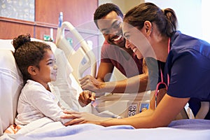 Pediatrician Visiting Father And Child In Hospital Bed photo