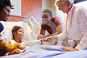 Pediatrician Visiting Parents And Child In Hospital Bed