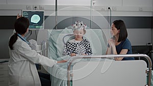 Pediatrician woman doctor discussing tomography expertise while monitoring sickness evolution
