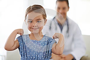 Pediatrician, young girl and arm with flex for strong, brave and happiness for treatment. Doctor, smile and child at
