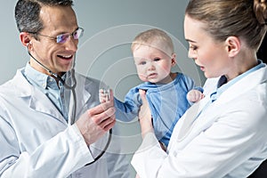 pediatricians checking breath of adorable photo