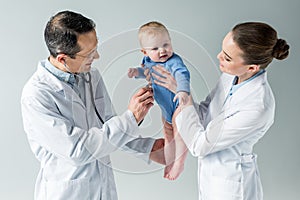 pediatricians checking breath of beautiful little baby photo