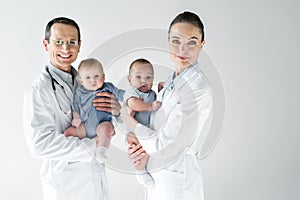 pediatricians holding little babies and looking at camera