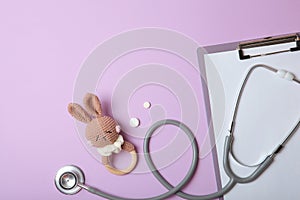 Pediatrics concept. Stethoscope and toy on a light background