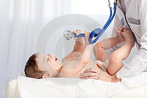 Pediatrics, a doctor examines a baby boy and uses a stethoscope to listen to the child`s breathing, the concept of medicine and