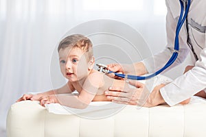 Pediatrics, a doctor examines a baby boy and uses a stethoscope to listen to the child`s breathing, the concept of medicine and