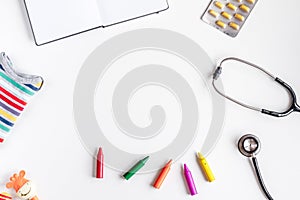 Pediatrics equipment with crayons , stethoscope white background top view space for text photo