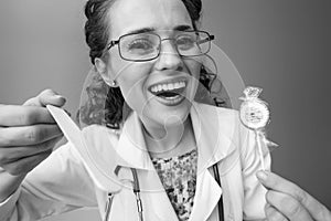 Pediatrist doctor with lollipop using spatula to examine throat