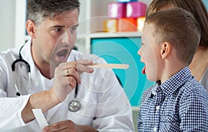 Pediatrist examinate boy's throat photo
