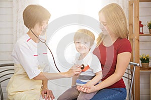 Pediatrist examinate young patient's lungs with stethoscope