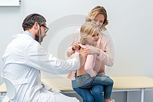 pediatrist listening to breath of little girl