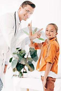 Pediatrist in white coat and child in clinic