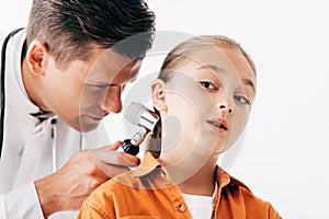 Pediatrist in white coat examining child with dermascope isolated on white