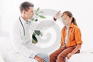 Pediatrist in white coat taking temperature