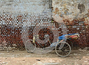 A pedicab parking on street with old wall in Amritsar, India