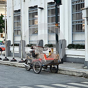 A pedicab stops on the side of the road