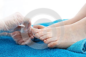 Pedicure in a beauty salon. Washing varnish on nails.