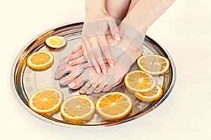 Pedicure and manicure in the spa salon with sliced oranges