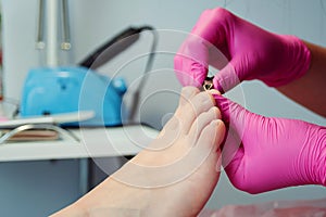 Pedicure master cuts toenails during pedicure procedure. Professional pedicure in the beauty salon