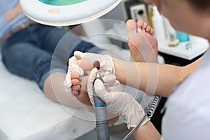 Pedicure SPA procedure in the beauty salon. Peeling feet pedicure procedure. Electric apparatus for pedicure.