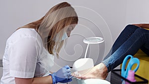 The pedicure technician doing nails on toes