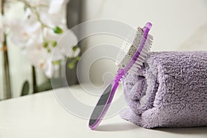 Pedicure tool with pumice stone and foot file near towel on white table, closeup. Space for text