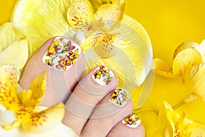 Pedicure with yellow orchids. photo