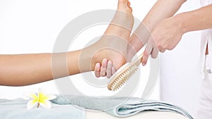 Pedicurist cleaning a woman foot