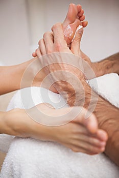 Pedicurist covering customers foot in soap