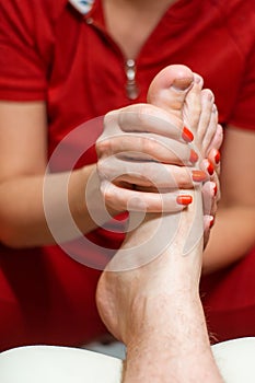 Pedicurist does massage of male feet