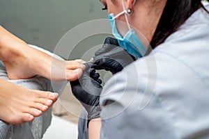 Pedicurist doing pedicure on toenails