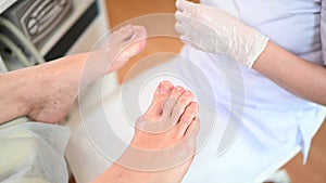Pedicurist doing professional medical pedicure procedure in beauty salon with special eguipment. Foot treatment in SPA