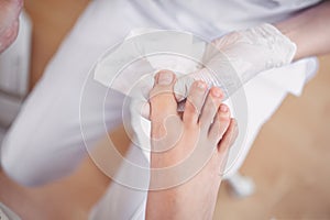 Pedicurist doing professional medical pedicure procedure in beauty salon with special eguipment. Foot treatment in SPA salon.