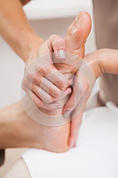 Pedicurist massaging customers foot