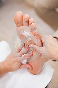 Pedicurist rubbing massage cream