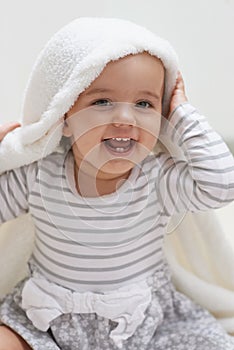 Peek-a-boo. Shot of a cute little baby girl sitting on the floor playing with her blanket.